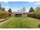 Well-maintained backyard with green lawn, covered patio, solar panels, and privacy fence, ideal for relaxation and recreation at 760 Niagara St, Denver, CO 80220