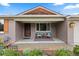 Inviting front porch with seating, brick facade, and a well-kept garden, perfect for relaxing at 760 Niagara St, Denver, CO 80220