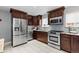 Contemporary kitchen featuring stainless steel appliances, stylish cabinetry, and bright tile flooring at 760 Niagara St, Denver, CO 80220
