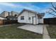 Spacious backyard with green grass, concrete patio, neutral home exterior, and a privacy fence at 5185 Alcott St, Denver, CO 80221