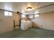 Basement laundry area featuring a washer, dryer, small windows, utility connections, and green floors at 5185 Alcott St, Denver, CO 80221