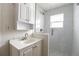 Bright bathroom featuring a walk-in shower with white subway tile and a white vanity sink with storage at 5185 Alcott St, Denver, CO 80221