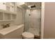 Updated bathroom featuring a walk-in shower with marble-look tile and a white vanity sink with storage at 5185 Alcott St, Denver, CO 80221