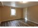 Bedroom with wood-look floors, neutral walls, a window, and a white door with hardware at 5185 Alcott St, Denver, CO 80221