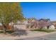 Inviting front of home with mature trees, landscaping, and an attached two-car garage at 3494 S Otis Ct, Lakewood, CO 80227