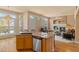 Open kitchen boasts stainless steel appliances, granite counters, and breakfast bar, flowing into the cozy living room at 3494 S Otis Ct, Lakewood, CO 80227