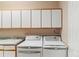 Bright laundry room featuring white cabinets, sink, and modern washer and dryer at 3494 S Otis Ct, Lakewood, CO 80227