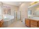Bright and spacious main bathroom with a soaking tub, walk-in shower, and vanity at 3494 S Otis Ct, Lakewood, CO 80227