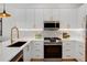 Modern kitchen featuring stainless appliances, white cabinets, and quartz countertops at 5142 W 44Th Ave, Denver, CO 80212