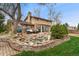 Inviting backyard featuring a stone water feature, patio with seating, and well-maintained landscaping, perfect for outdoor enjoyment at 7106 S Kendall Blvd, Littleton, CO 80128