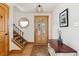 Inviting foyer with hardwood floors, decorative mirror, and staircase at 7106 S Kendall Blvd, Littleton, CO 80128