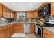 Updated kitchen with stainless steel appliances, granite countertops, tile backsplash, and wood cabinets, offering functionality and style at 7106 S Kendall Blvd, Littleton, CO 80128
