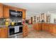 Well-equipped kitchen with stainless steel appliances, granite counters, and wooden cabinets with an open view of the living spaces at 7106 S Kendall Blvd, Littleton, CO 80128