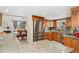 Well-lit kitchen featuring stainless steel appliances, granite countertops, and wood cabinetry with a view of the dining area at 7106 S Kendall Blvd, Littleton, CO 80128