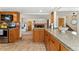 Bright kitchen showcasing granite counters, wood cabinets, and an open layout that flows into the living area with a fireplace at 7106 S Kendall Blvd, Littleton, CO 80128
