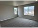 Unfurnished bedroom with large windows, carpet, and a view of new construction in the area at 1783 Jennifer St, Brighton, CO 80601