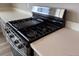 Close-up of a stainless steel gas stove on top of a white countertop at 1783 Jennifer St, Brighton, CO 80601