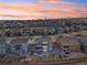 Expansive aerial view of neighborhood homes with sunset hues, showcasing a well-planned community at 17829 W 95Th Pl, Arvada, CO 80007