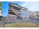 Exterior view of a backyard with grass, a hot tub, a stairway to a raised deck, and professional landscaping at 17829 W 95Th Pl, Arvada, CO 80007