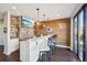 Custom basement bar with stone accents, wood paneling, and sports memorabilia, with modern fixtures at 17829 W 95Th Pl, Arvada, CO 80007