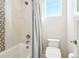 Modern bathroom features a shower-tub combo with a tiled accent wall and a comfort-height toilet at 17829 W 95Th Pl, Arvada, CO 80007
