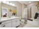 Bright bathroom features a white vanity, a large mirror, and a shower-tub combination with a patterned curtain at 17829 W 95Th Pl, Arvada, CO 80007