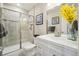 Modern bathroom featuring a glass-enclosed shower, neutral tiles, and sleek fixtures at 17829 W 95Th Pl, Arvada, CO 80007
