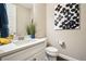 Modern powder room with white vanity, stylish mirror, and chic decorative accents at 17829 W 95Th Pl, Arvada, CO 80007