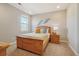 Cozy bedroom features a wooden bed frame with a yellow throw blanket and decorative wall art at 17829 W 95Th Pl, Arvada, CO 80007