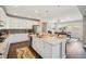 Bright kitchen with island seating next to dining area, stainless appliances, and dark hardwood floors at 17829 W 95Th Pl, Arvada, CO 80007