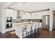 Modern kitchen featuring white cabinetry, granite countertops, stainless steel appliances, and island seating at 17829 W 95Th Pl, Arvada, CO 80007