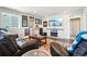 Relaxing living room featuring a TV over a fireplace, leather seating, and modern decor at 17829 W 95Th Pl, Arvada, CO 80007