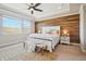 Tranquil main bedroom with wood accent wall, tray ceiling, and picturesque window view at 17829 W 95Th Pl, Arvada, CO 80007