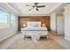 Elegant main bedroom featuring wood accent wall, tray ceiling, and cozy bench at 17829 W 95Th Pl, Arvada, CO 80007