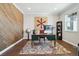 Stylish home office with wood accent wall, large window, and ample workspace at 17829 W 95Th Pl, Arvada, CO 80007