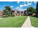 Neatly landscaped townhome with brick and wood exterior, welcoming front entrance and walkway at 3855 S Monaco St # 170, Denver, CO 80237