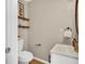 Powder room featuring a white sink, a copper faucet and fixtures, and open shelving at 6382 W Byers Pl, Lakewood, CO 80226