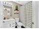 Bathroom featuring a white vanity, black and white tile flooring, and a shower with striped curtain at 6382 W Byers Pl, Lakewood, CO 80226