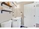 Clean bathroom with white fixtures, dark hardware, decorative shelving and bright lighting at 6382 W Byers Pl, Lakewood, CO 80226