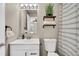 Bright bathroom with open shelving for towels and a white vanity with modern hardware at 6382 W Byers Pl, Lakewood, CO 80226