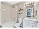 Bathroom features a shower and tub combination, bright lighting and white vanity at 6382 W Byers Pl, Lakewood, CO 80226