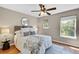 Comfortable bedroom featuring a ceiling fan, a plush bed, and a large window providing ample natural light at 6382 W Byers Pl, Lakewood, CO 80226