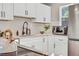 Bright kitchen featuring white cabinets, black hardware, undermount sink, and stainless steel appliances at 6382 W Byers Pl, Lakewood, CO 80226