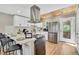 Modern kitchen featuring white cabinets, stainless steel appliances, a breakfast bar, and a light wood ceiling at 6382 W Byers Pl, Lakewood, CO 80226