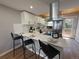 Modern kitchen with stainless steel appliances, sleek white cabinets, and a functional breakfast bar, perfect for cooking at 6382 W Byers Pl, Lakewood, CO 80226