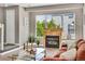 Living room with a modern fireplace, natural light, and a comfortable seating area, creating a warm space at 6382 W Byers Pl, Lakewood, CO 80226