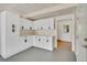 The garage has a utility area with white cabinets and black hardware, leading to a back door at 6382 W Byers Pl, Lakewood, CO 80226