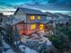 Two-story home with a stone patio, covered porch and landscaping; lovely evening view at 13717 Ashgrove Cir, Parker, CO 80134