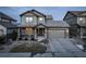 Two-story house with gray siding, stone accents, and a two-car garage at 13717 Ashgrove Cir, Parker, CO 80134