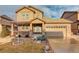 Two-story house with beige siding, stone accents, and a two-car garage at 13717 Ashgrove Cir, Parker, CO 80134